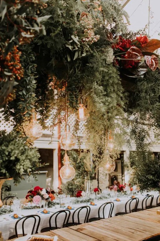 a botanical wedding venue with lush greenery, bright blooms and leaves all over the space looks amazing