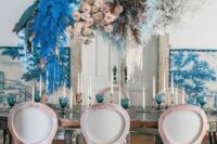 a bright and catchy floral wedding installation with blush roses, blue hydrangeas, bold blue and dark leaves, baby’s breath is a fantastic accent