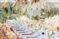 a bright and chic spring wedding reception with bright blooms, greenery, a lush chandelier of pampas grass and blush flowers
