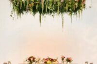 a bright greenery and floral installation overheads is a bold and cool idea for a summer or fall reception