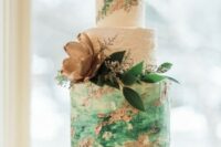 a bright white, green and copper wedding cake with watercolor tiers, leaves and a gilded flower is a romantic idea