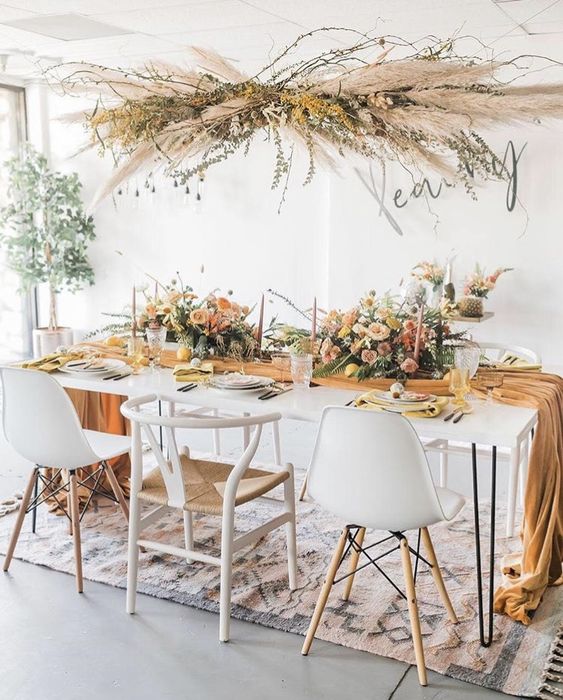a dried grass installation with pampas grass, greenery, branches is a gorgeous idea for a boho wedding