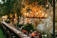a fresh botanical wedding venue with a greenery installation with antler chandeliers, greenery and floral centerpieces