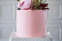 a light pink wedding cake with textural buttercream, a pink peony and usual and dark foliage on top for a summer to fall wedding