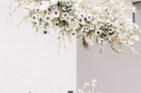 a lovely and cool white anemone wedding nstallation with some blooming cherry branches is a gorgeous idea to decorate over the reception