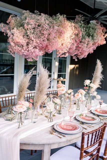 a lovely pink baby's breath overhead wedding insallation, pink roses and glass plates make the space cute, lovely and chic