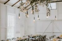 a lush foliage wedding decoration with cotton branches and bulbs hanging down
