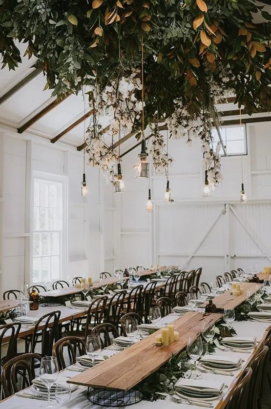 a lush foliage wedding decoration with cotton branches and bulbs hanging down
