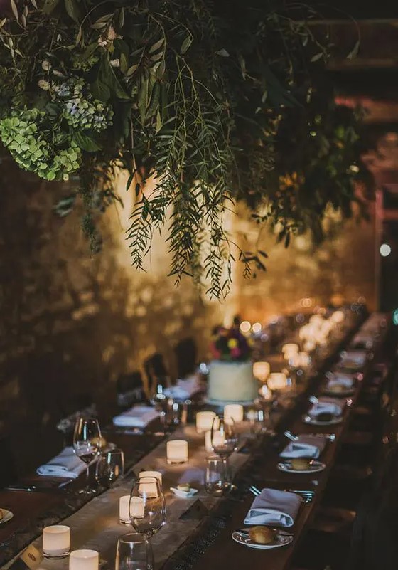 a lush greenery decoration over the reception creates an outdoorsy feeling inside and makes the space more intimate