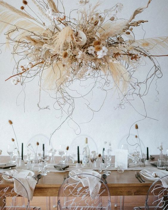 a messy and catchy dried wedding installation with pampas grass, dried flwers and fresh ones, branches and twigs is wow