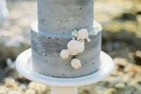 a minimalist grey concrete wedding cake wiht neutral blooms is a very cool idea for a coastal wedding