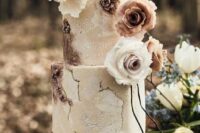 a neutral and rust-colored textural wedding cake with watercolors, with neutral and blooms blooms looks like a masterpiece