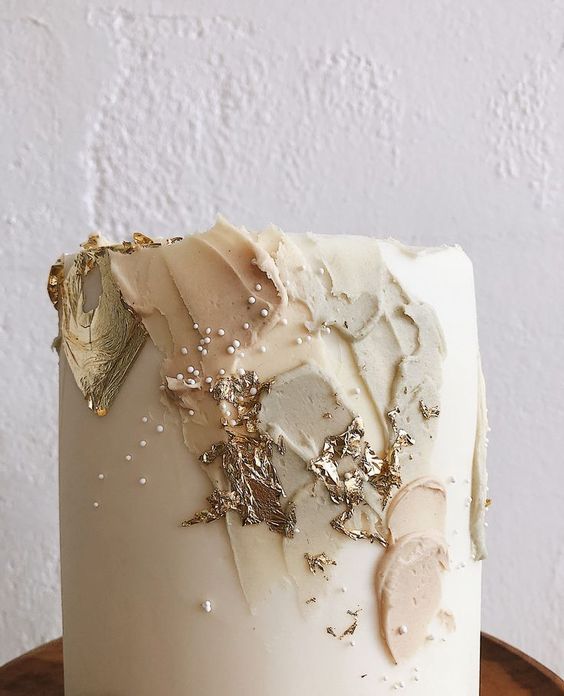 a neutral wedding cake with some gold foil, brushstrokes and polka dots is a lovely idea for a spring or summer wedding
