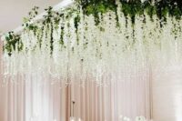 a neutral wedding reception with delphinium overhead installations pumped up with lights hanging down