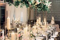 a refined formal wedding reception with a lush decoration of blush blooms and greenery overhead, lots of candles and pink flowers