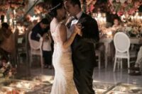 a romantic dance floor with lights and fresh blooms under it and bold and pastel blooms over the dance floor is amazing for a glam wedding