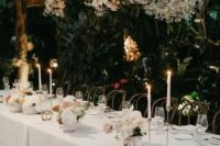 a sophisticated floral wedding installation with white and pink roses, baby’s breath, greenery and matching arrangements on the table