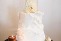 a white textural wedding cake with a clear acrylic separator with white roses inside is a romantic and sophisticated idea