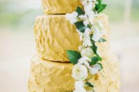 a yellow textural buttercream wedding cake with greenery and neutral blooms is a cool and bold idea for spring