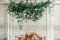 an ethereal overhead greenery decoration adds a soft touch to industrial chairs and a fresh touch