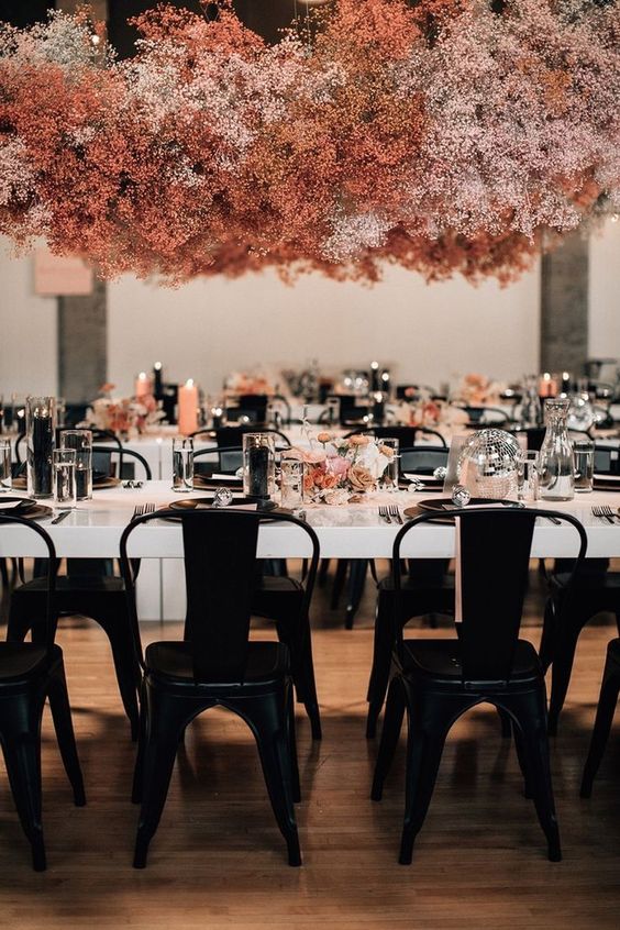 an overhead blush and pink baby's breath floral installation over the table is a gorgeous idea to add color to the space