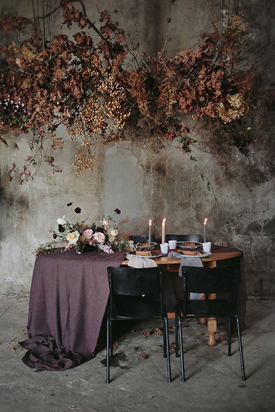 an oversized dark wedding installation of dried blooms, foliage and branches for a sophisticated moody wedding in the fall