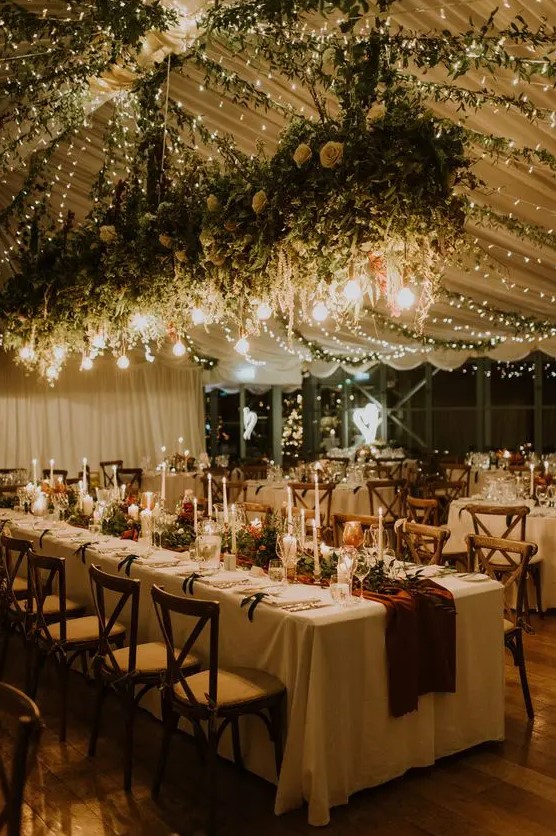 string lights and Edison bulbs hanging over the venue and candles on the tables illuminate the space in a gorgeous way