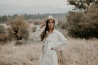 05 a white denim bridal jacket with fringe on the sleeves, a boho lace wedding dress and a white hat for a boho bride