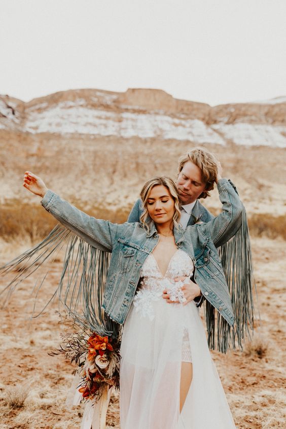a blue denim jacket with long fringe is a cool solution for a boho bride, and you can attach this fringe yourself