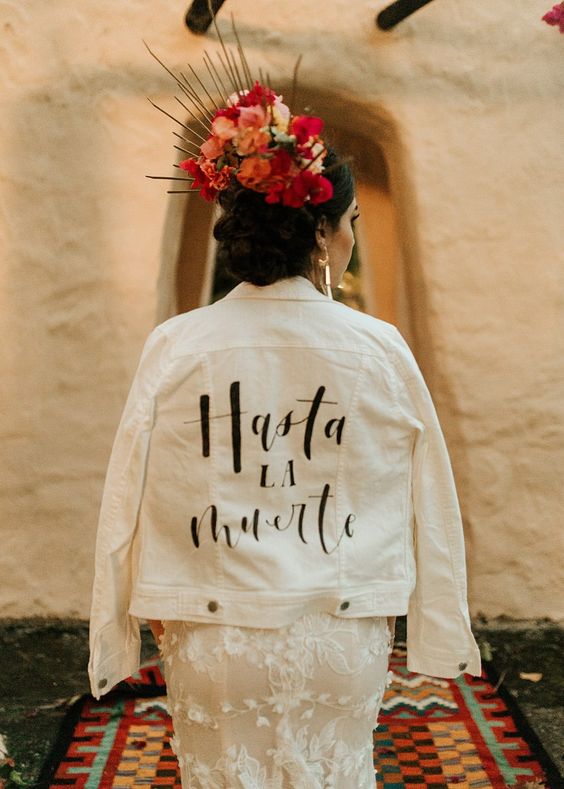 a white denim jacket personalized with black letters for a Day of the Dead wedding or a Frida Kahlo one
