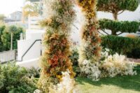 08 a lovely and creative baby’s breath wedding arch spray painted in various colors, with additional blooms on both sides