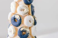 11 a lovely white and navy glazed donut tower with gilded touches is a chic and bold idea for a modern wedding