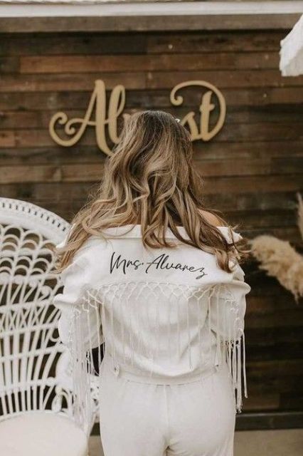 a white jacket with black calligraphy and macrame and long fringe is a gorgeous idea for a boho bride