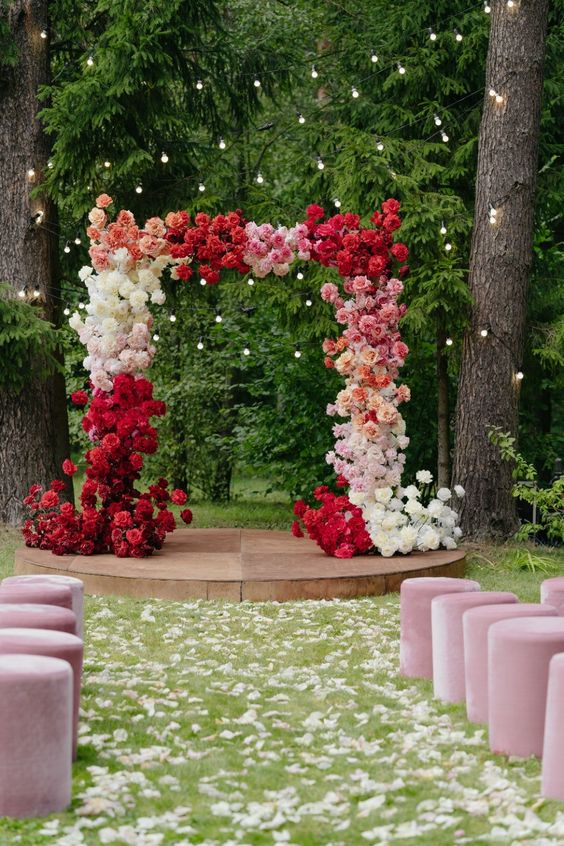 a bright color block wedding arch decorated with white, blush, pink and deep red roses is a fantastic color statement