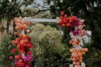 17 a bright wedding arch with a color block effect, with orange, red, hot pink, blush and white roses is wow