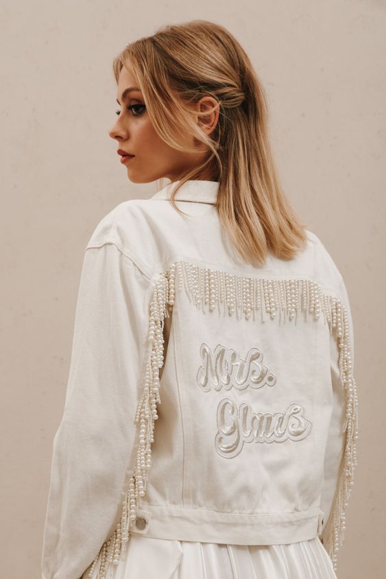 a white denim bridal jacket personalized with embroidery and white pearl fringe is a very sophisticated idea