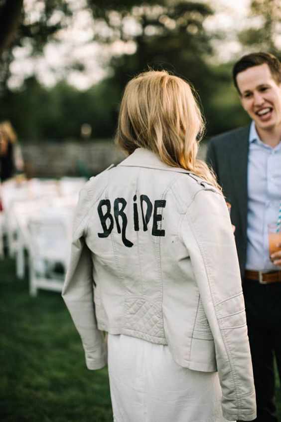 a white leather jacket personalized with black letters is a chic and stylish idea to rock at the wedding