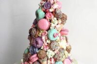 19 a colorful and whimsical wedding cake with chocolate drip, bright and pastel macarons, glazed donuts, candies and ice cream cones