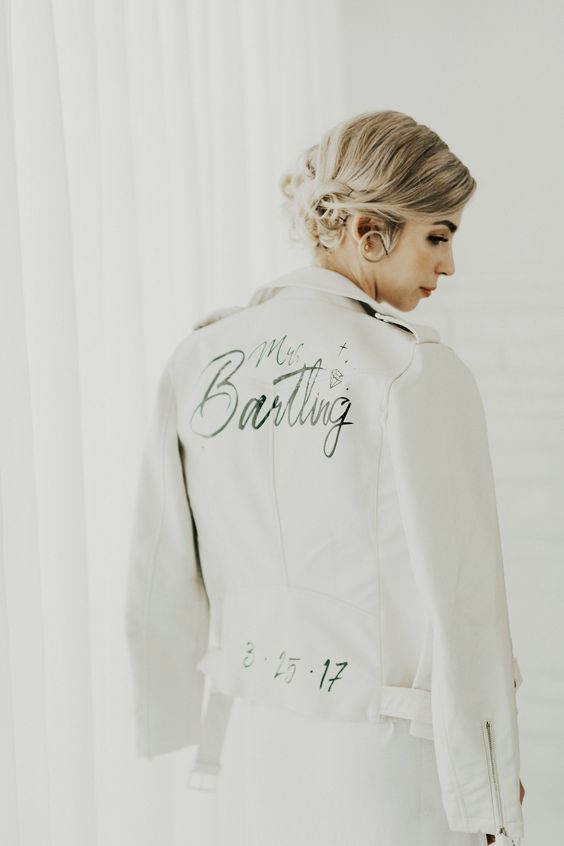 a white leather jacket with black calligraphy, stars and a wedding date is a cool idea and this paint can be removed if you wanna wear it afterwards