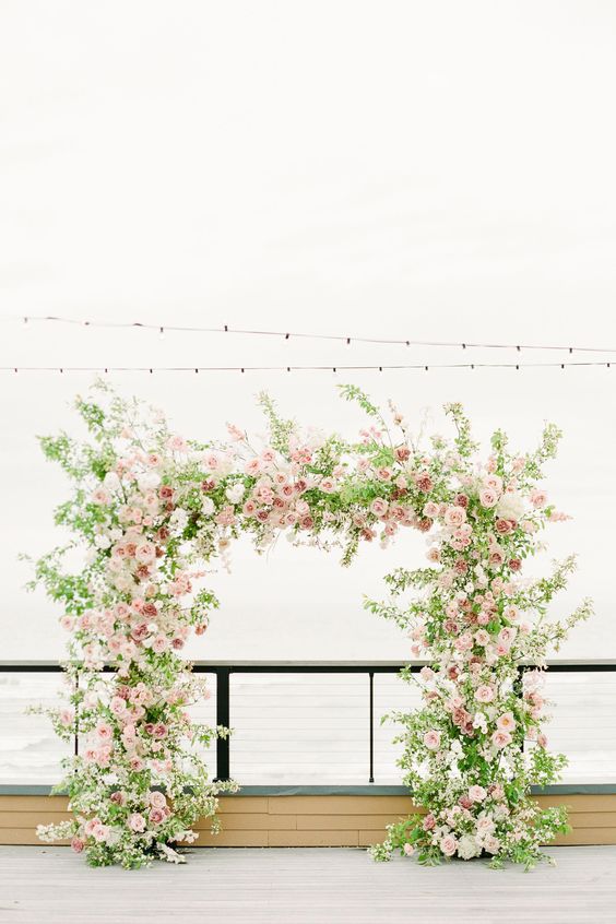 a lovely garden wedding arch done with greenery, blush, pink and mauve roses is a beautiful solution for a spring or summer wedding