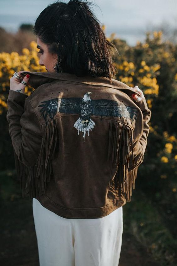 a brown leather jacket with fringe and a painted eagle is a great idea for a boho or western bride