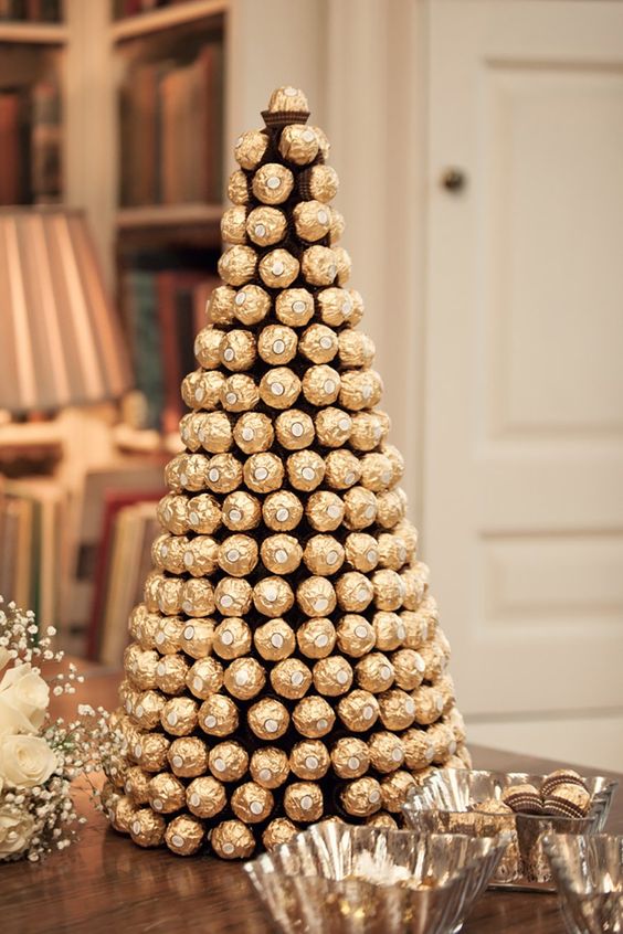 a gold wedding tower of Ferrero Roche is a nice alternative to a usual wedding cake, and it looks elegant
