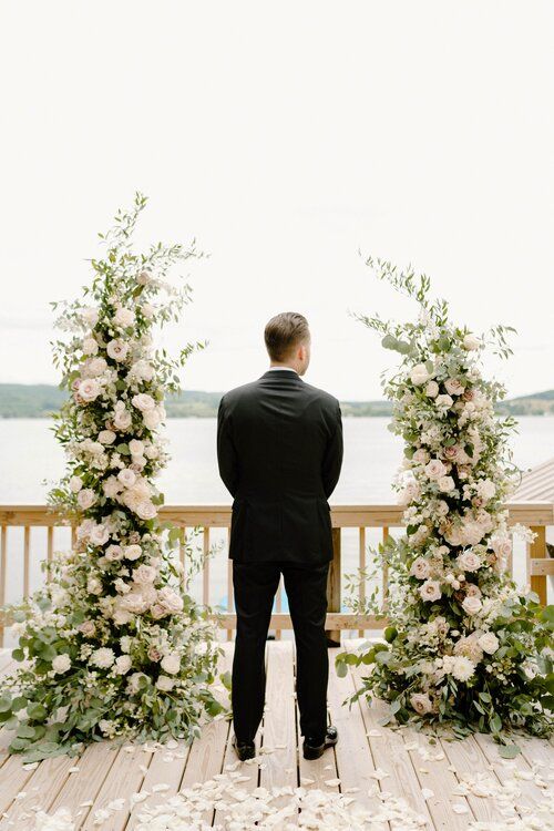 a pretty wedding altar with greenery and blush roses plus a lake view is a romantic idea for a spring or summer wedding