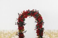 25 a refined wedding ceremony space with gold and white chairs and a green and red rose wedding arch that makes a statement
