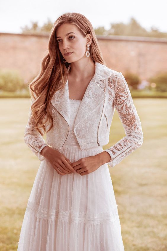 a boho A-line wedding dress and a lace cropped moto jacket as a creative and bold accessory for a wedding