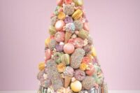 27 a quirky pastel wedding cake with chocolate drip, macarons, glazed donuts, ice cream cones and edible blooms