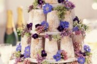 28 a tower of mini naked wedding cakes decorated with lilac, violet and deep purple blooms and greenery for a relaxed wedding
