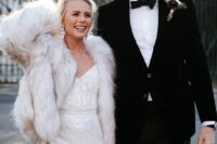 38 a glam shiny wedding dress paired with a white faux fur jacket and glam flower earrings are an amazing glam bridal look