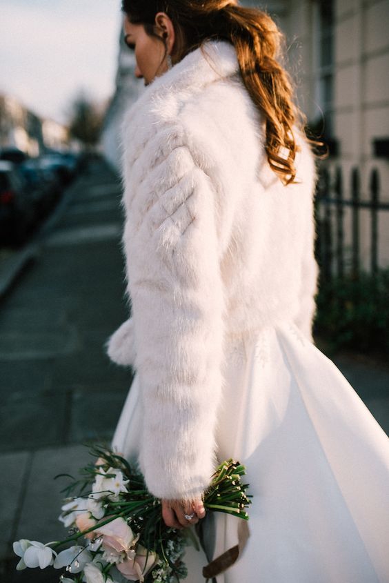 a white faux fur bridal jacket is a timeless solution for a winter bride, such a piece will match many looks