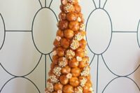 a beautiful croquembouche wedding cake with caramel and sugar detailing, sugar blooms and a sugar rose on top